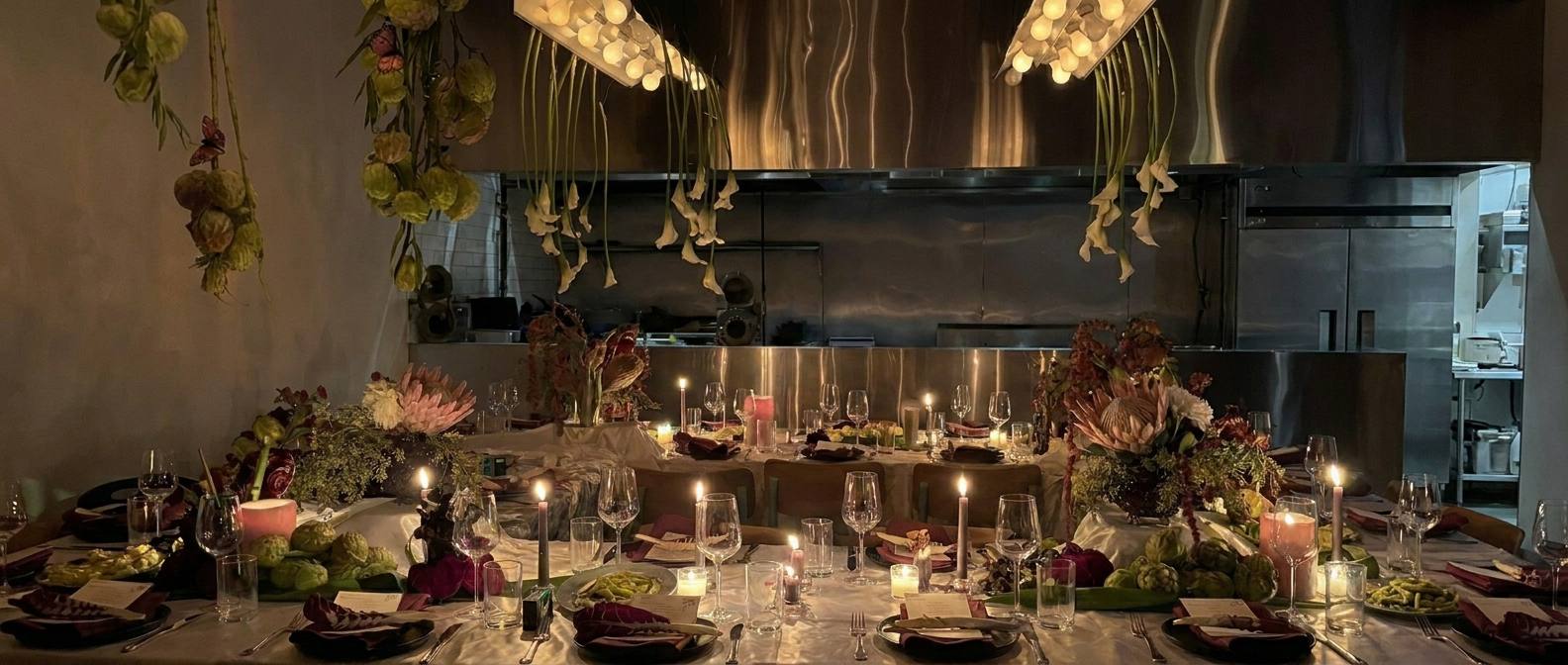 Candlelit communal table with floral installation at TASHCA